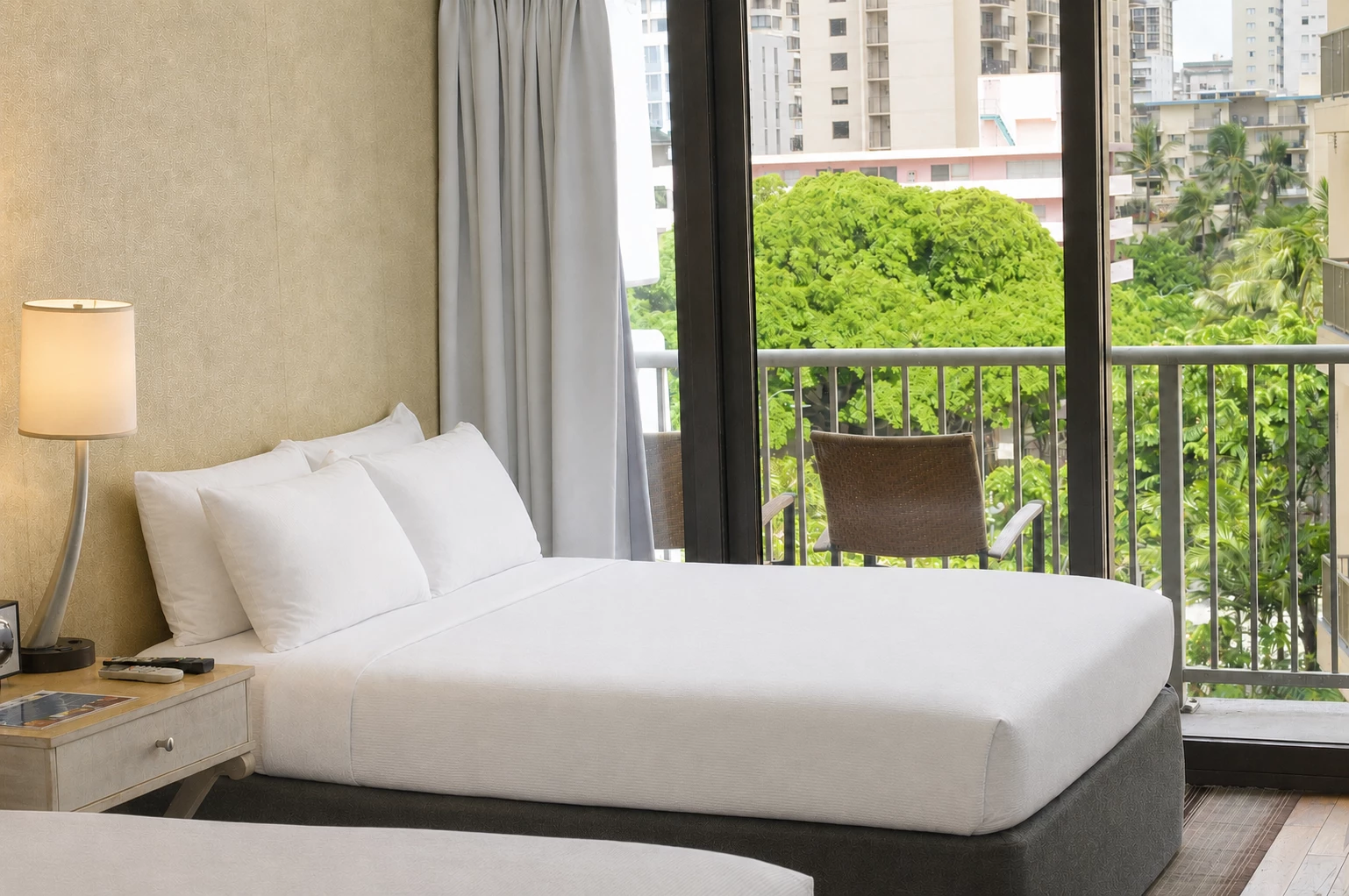 A hotel room with a large bed, a balcony, and a city view.