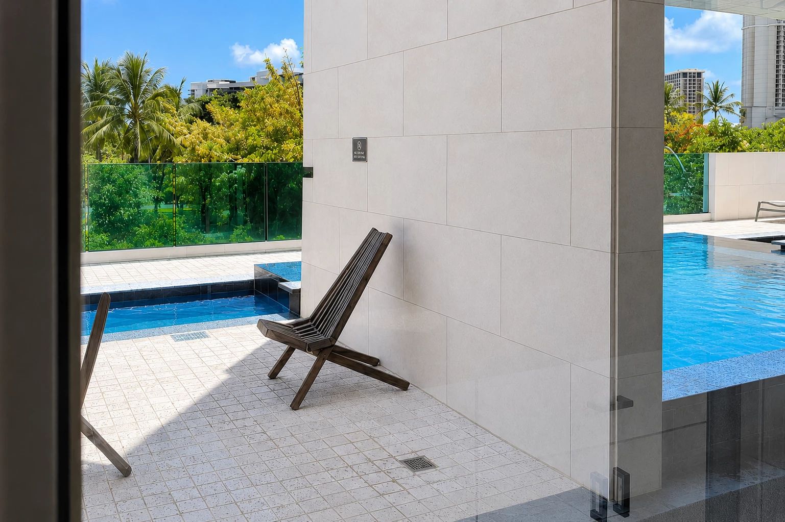 A poolside area with a chair and a view of the surrounding landscape.