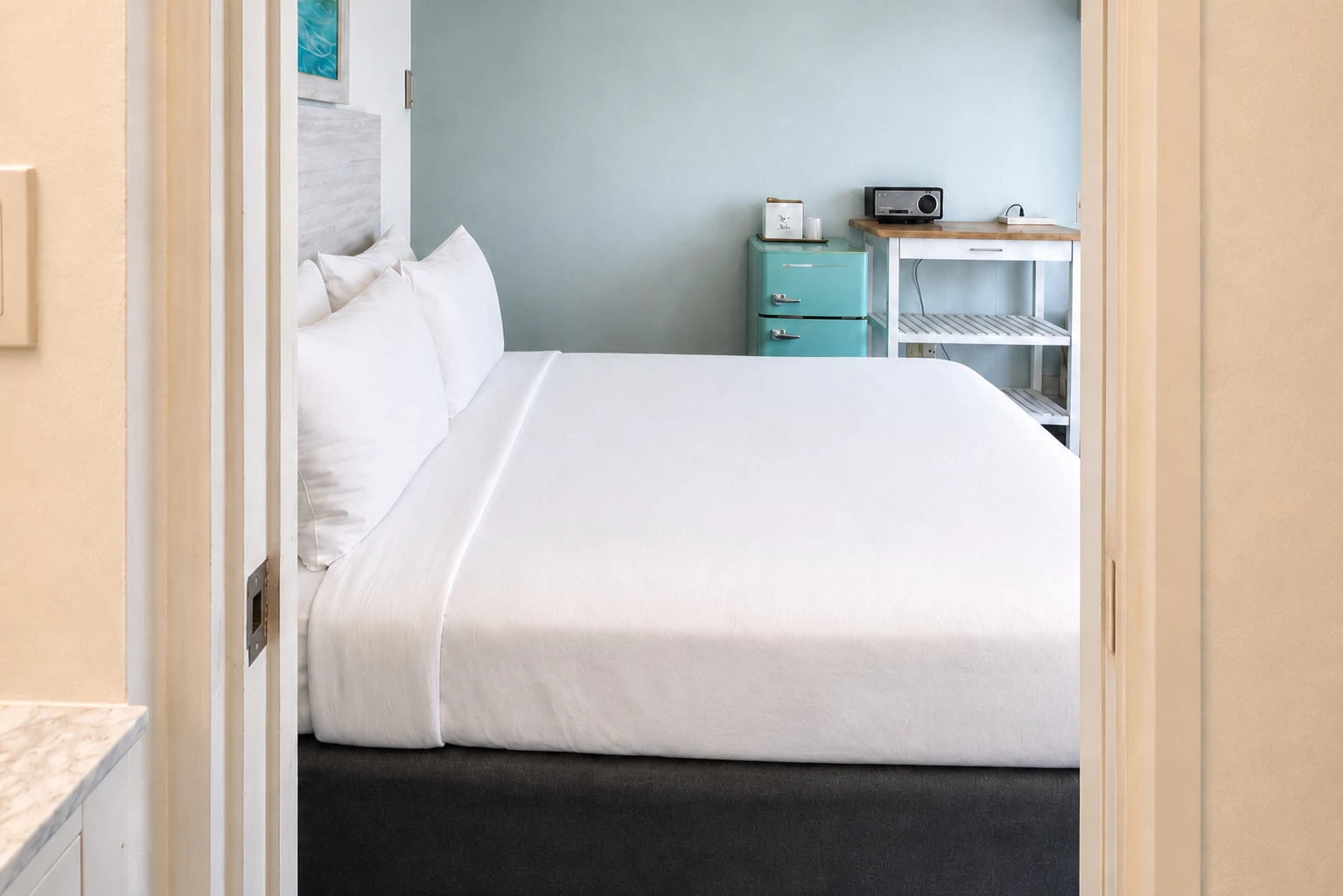 A hotel room with a bed and a small refrigerator
