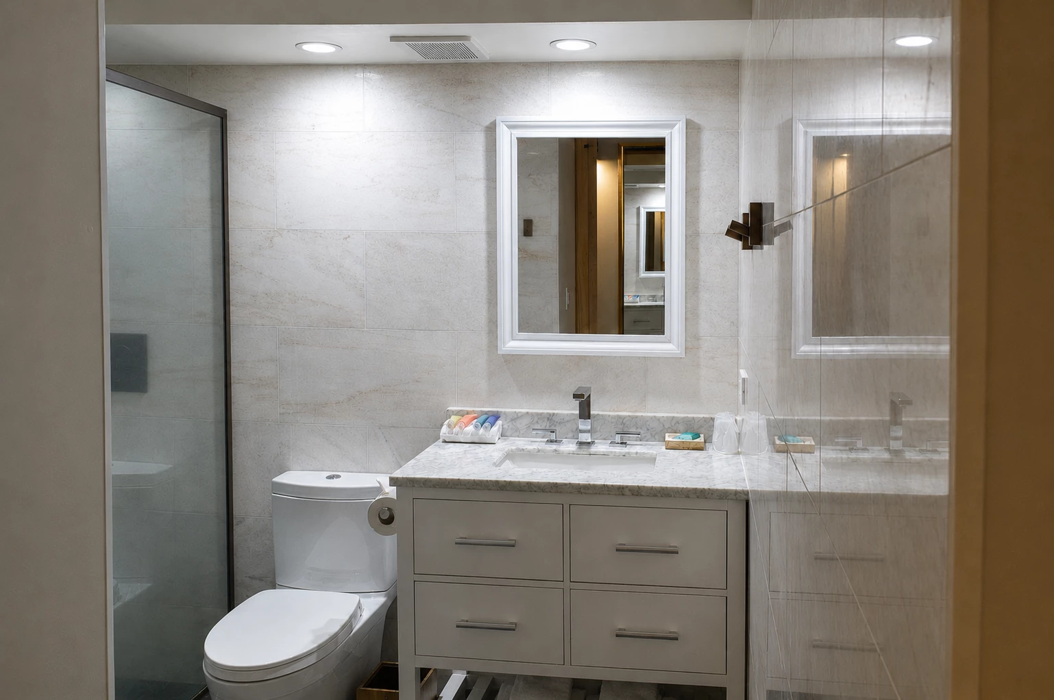 A modern bathroom with a glass-enclosed shower, double vanity, and marble countertop.