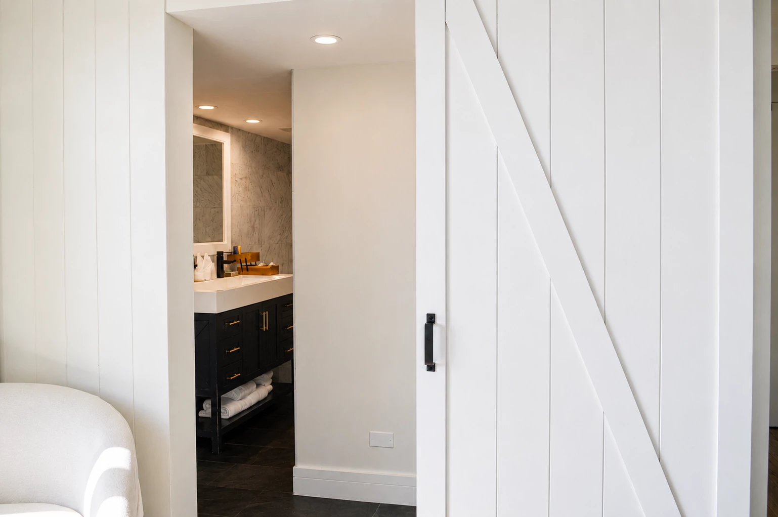 A bathroom with a white sink and black cabinets
