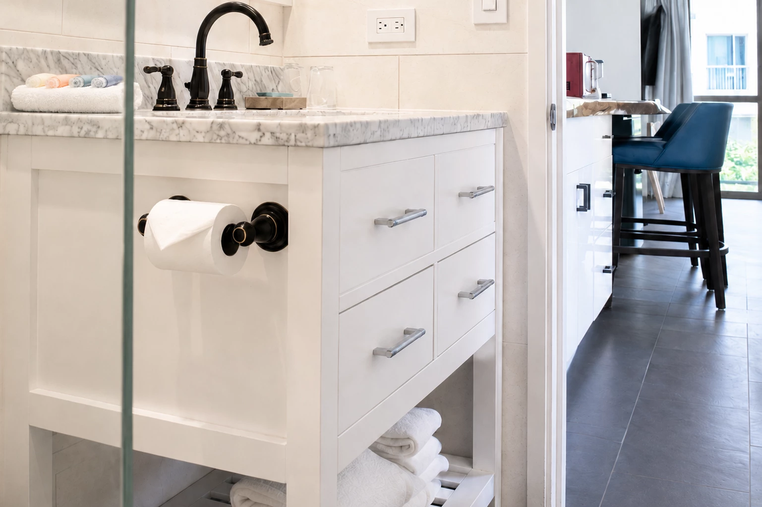 A clean bathroom with a marble countertop and black faucet