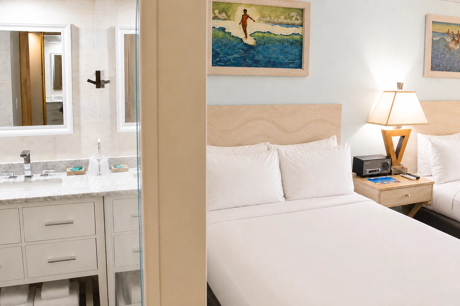 A hotel room with a white bed, nightstand, and vanity