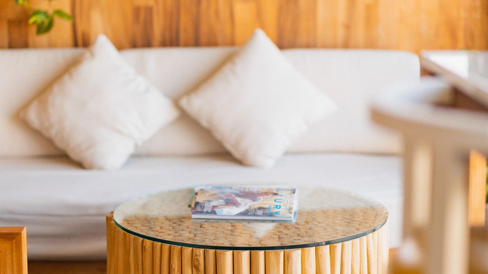 A cozy lobby with a white couch, a wooden coffee table, and magazines.