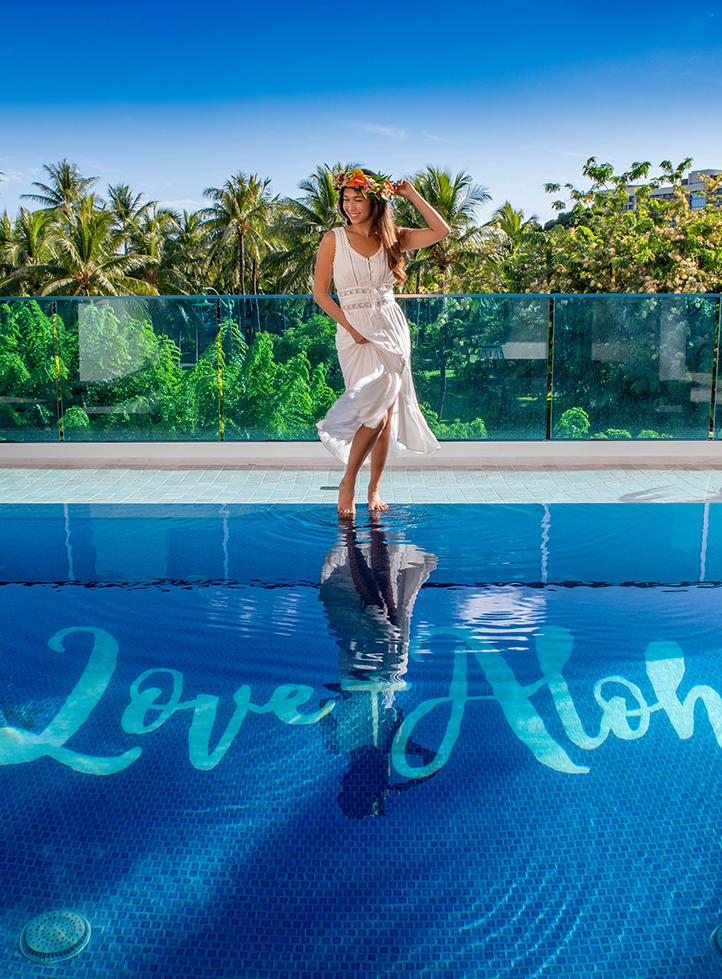 a woman in a white dress standing on a pool
