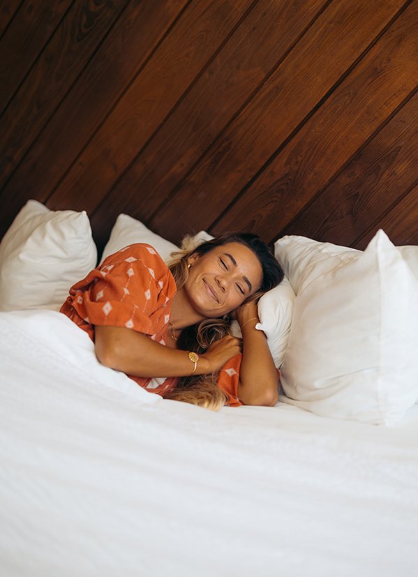 a woman lying in bed with her eyes closed