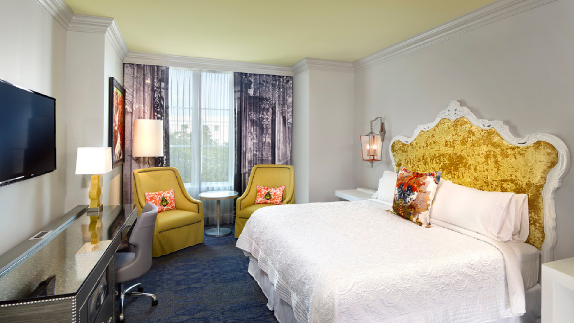 a room with a bed and chairs