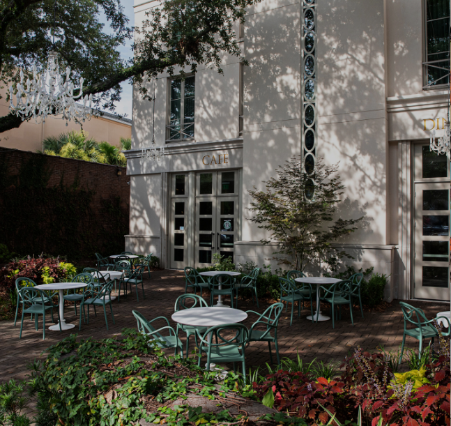 a white building with tables and chairs outside