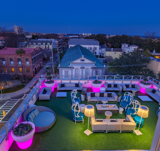 a rooftop patio with furniture and lights