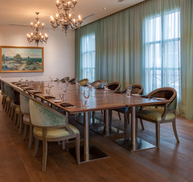 a long table with chairs and chandelier