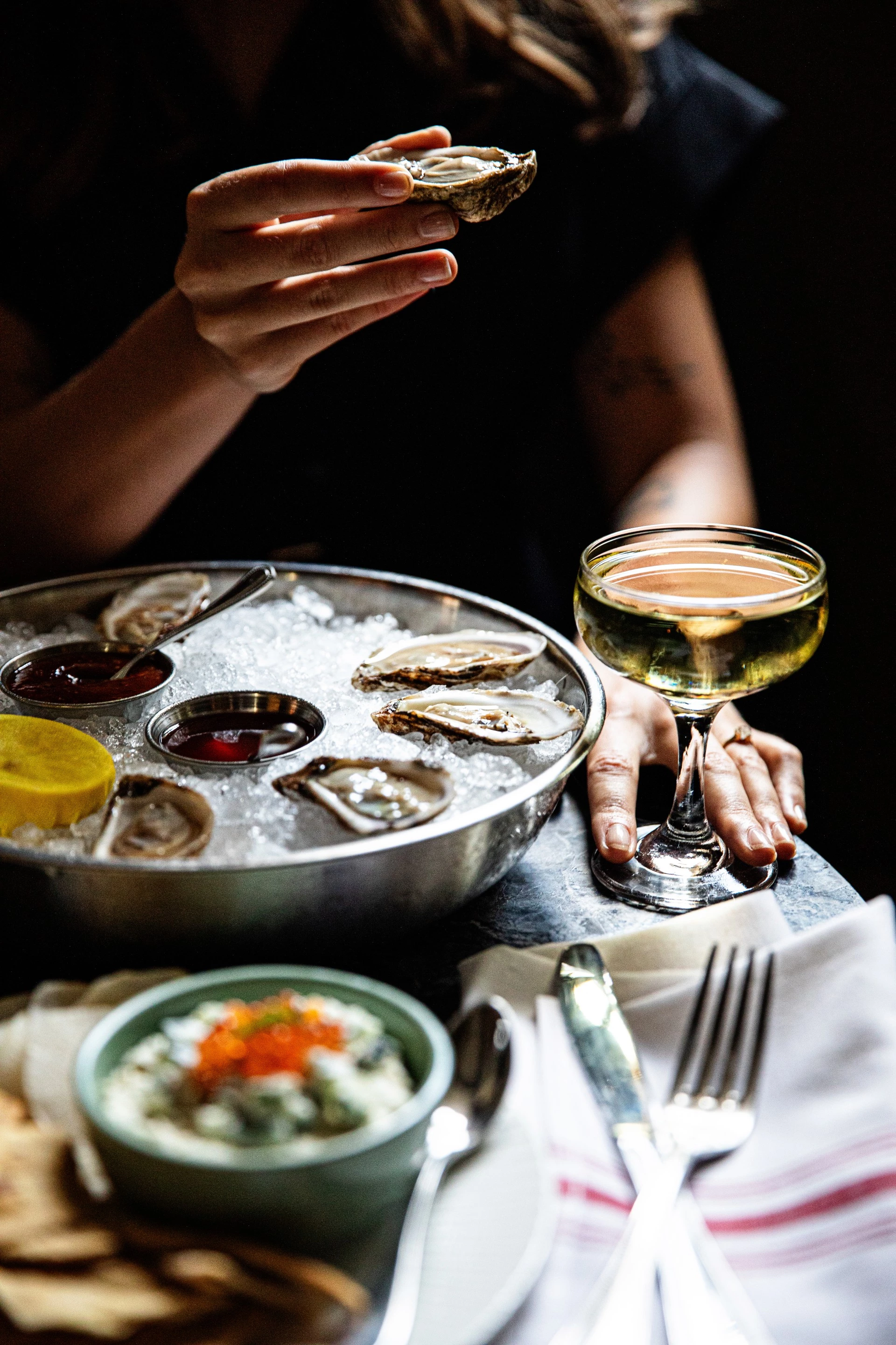 a bowl of oysters and a glass of wine