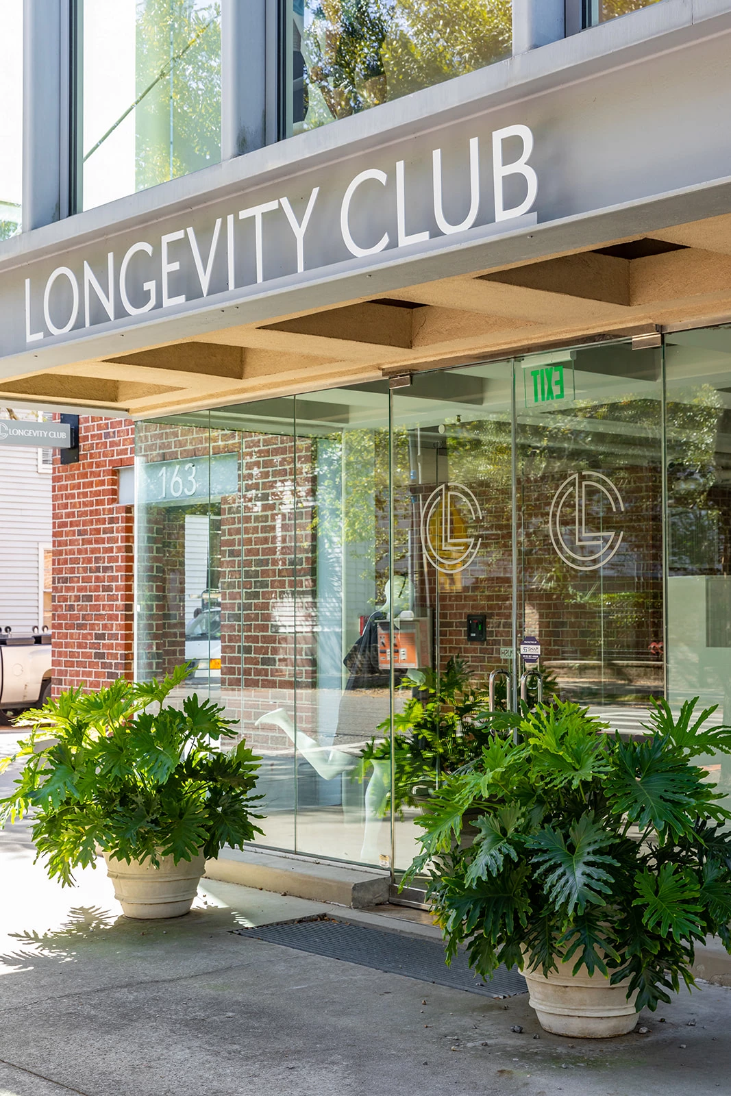 a building with glass doors and plants