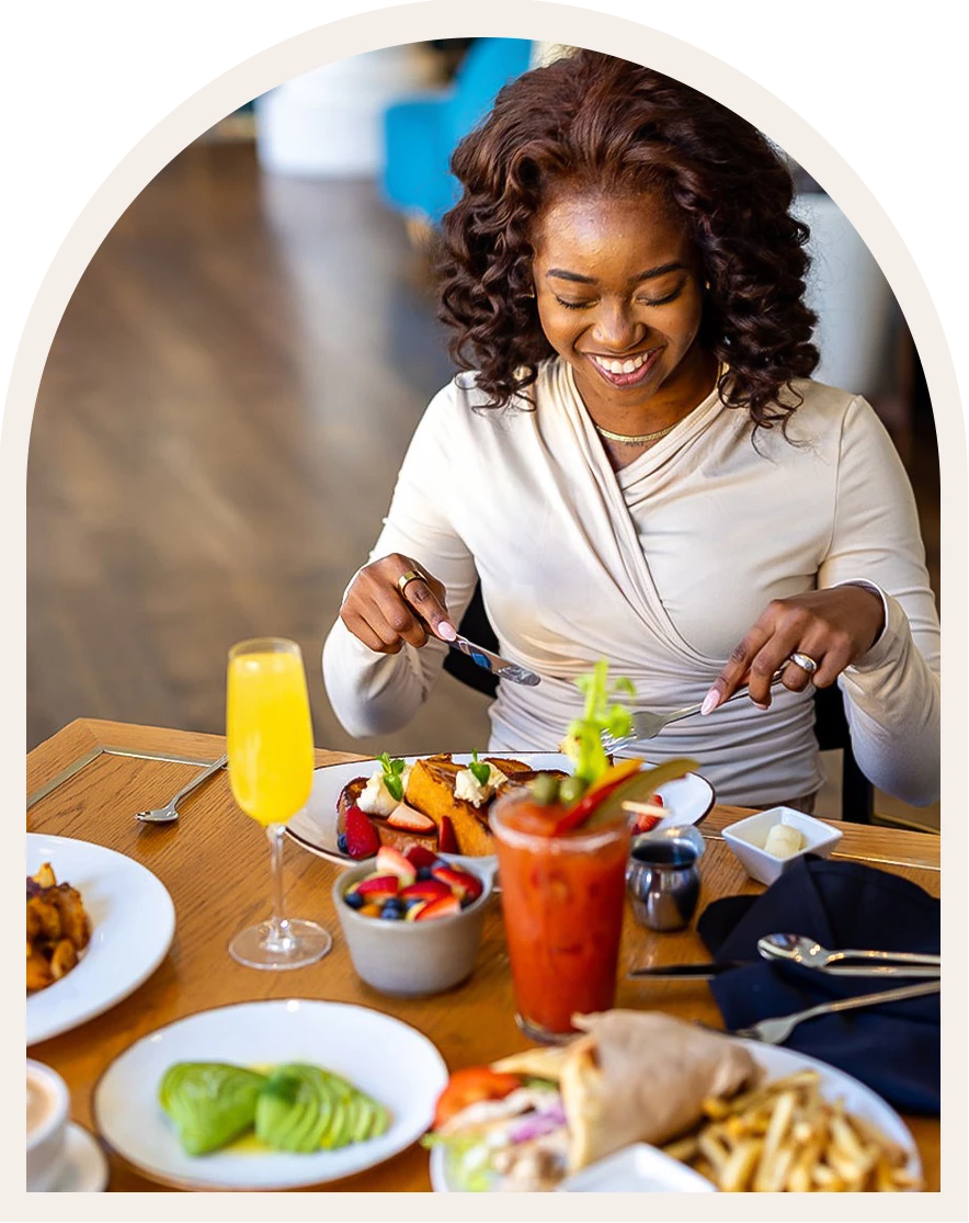 a woman sitting at a table with food