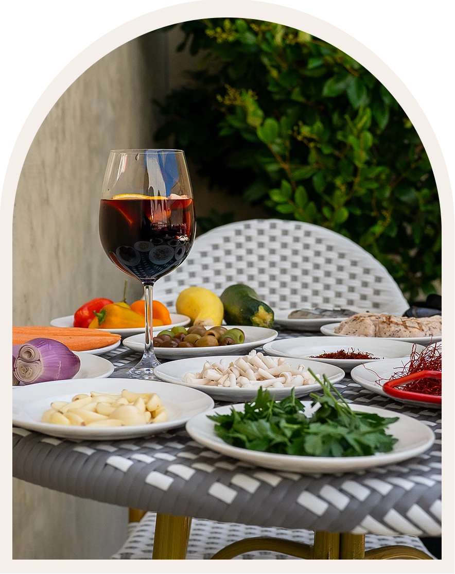 a table with plates of food and a glass of wine