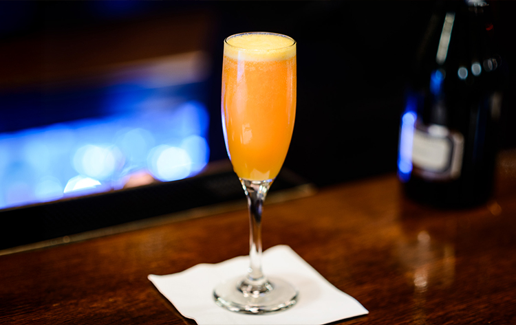 a glass of orange liquid on a table