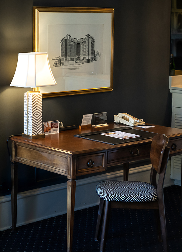 a desk with a lamp and a picture on the wall