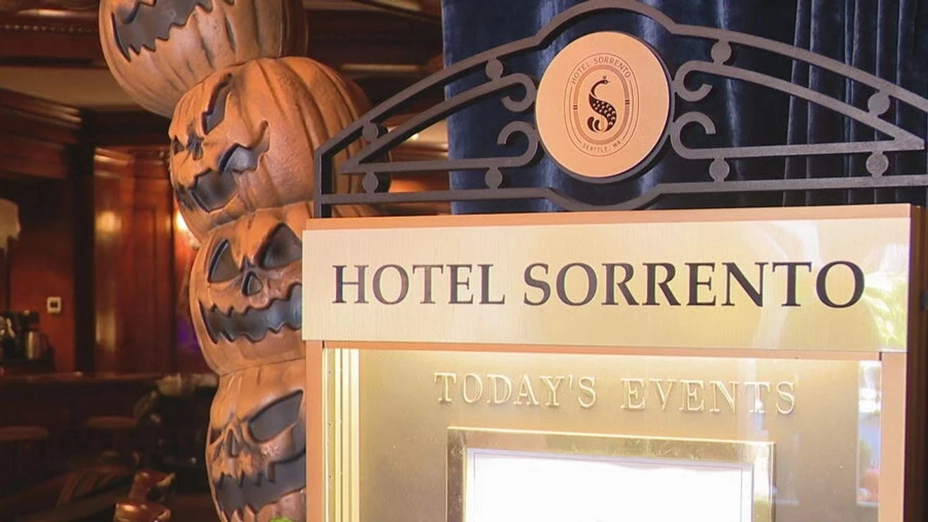a sign with carved pumpkins in the background