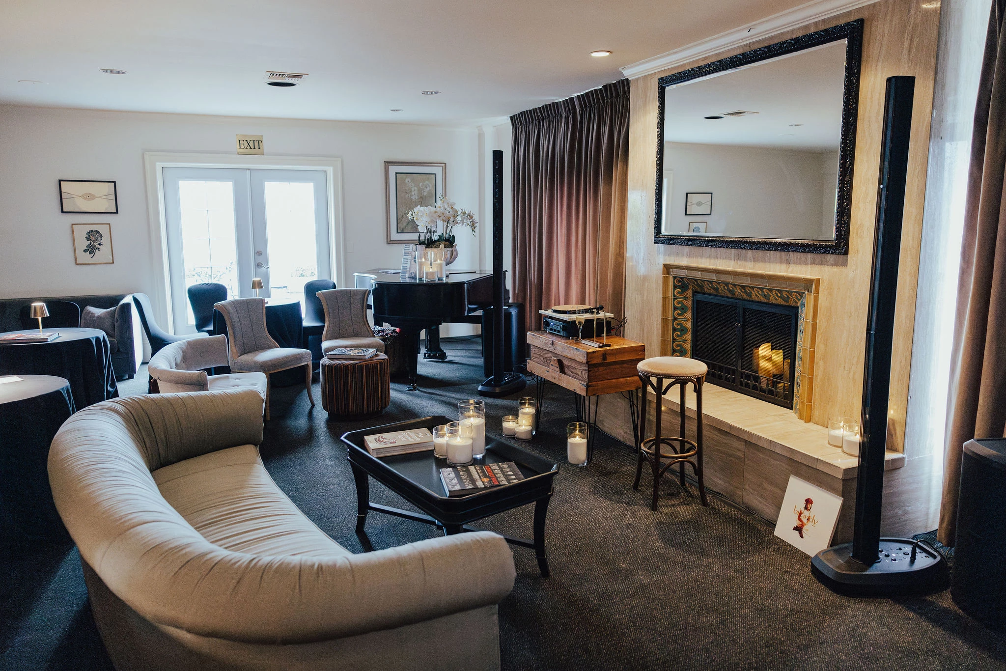 A luxurious lounge with a fireplace, piano, and seating area.