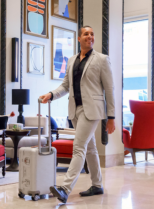 a man in a suit walking with a suitcase