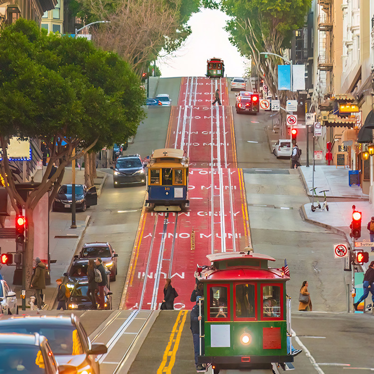 a trolley cars and cars on a street
