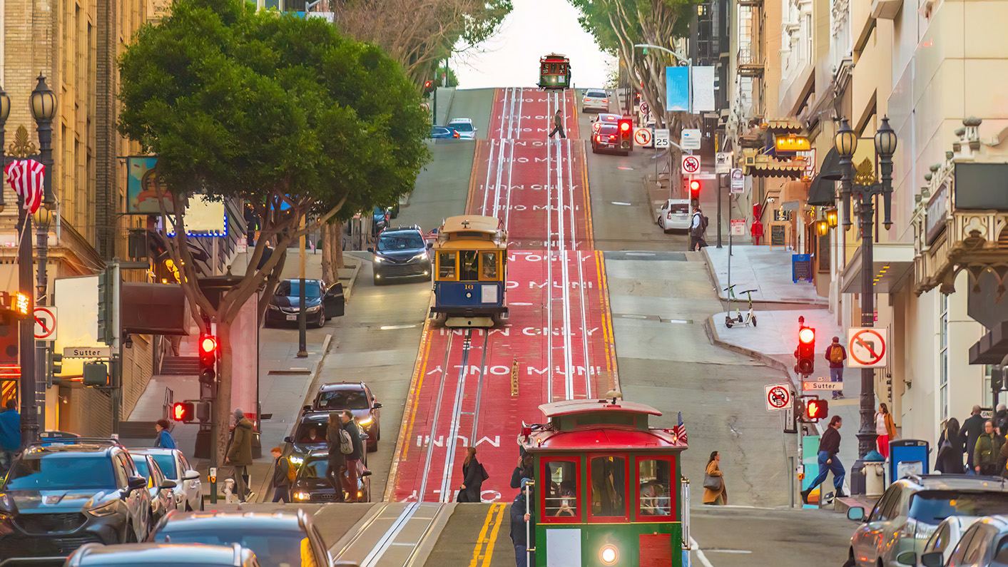 a trolley cars and cars on a street