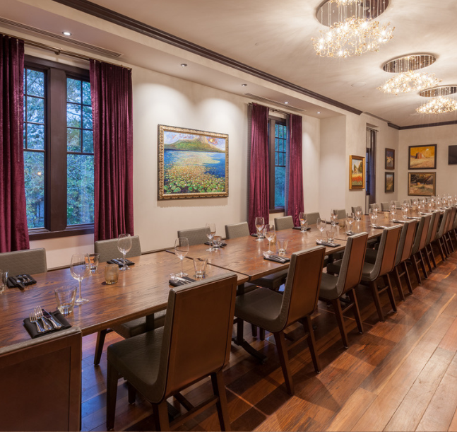 a long table with chairs and glasses in a room