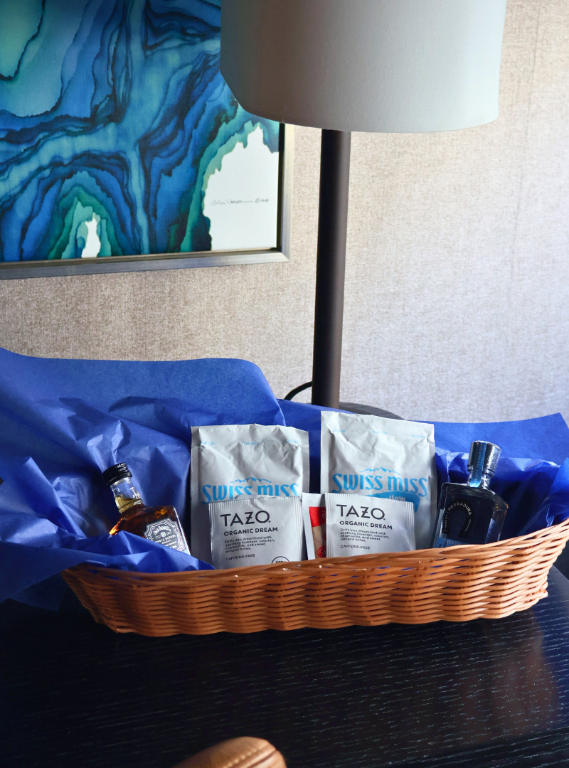 a basket with a bottle of alcohol and a bag of cream