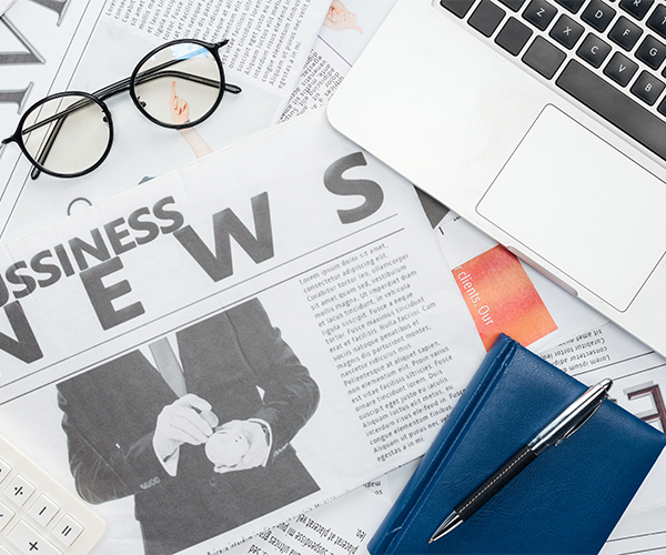 a newspaper and a pen on top of papers