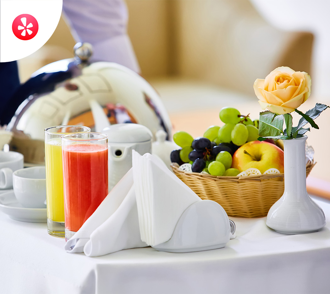 a table with a basket of fruit and a flower