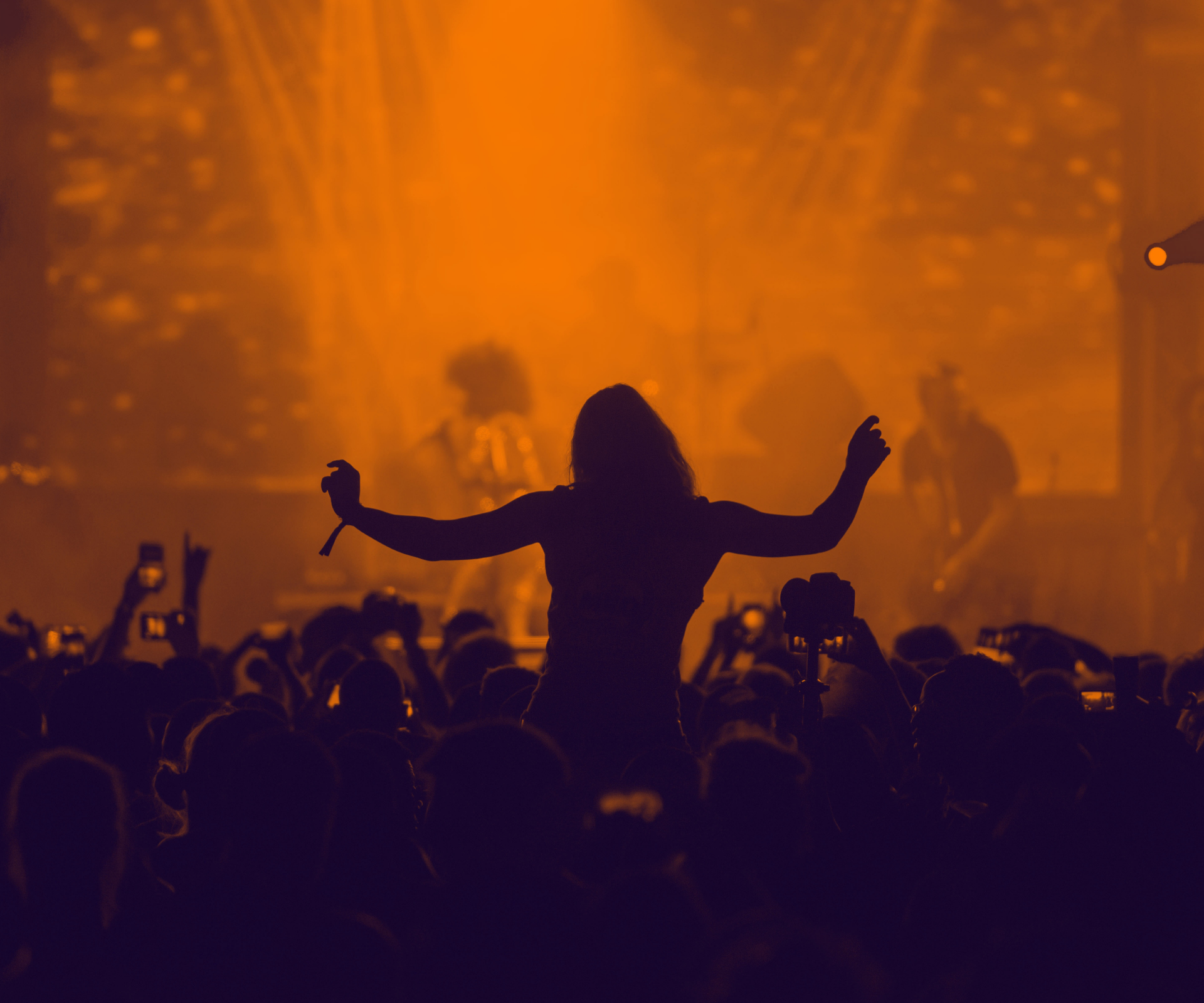 a person with their arms up in front of a crowd of people