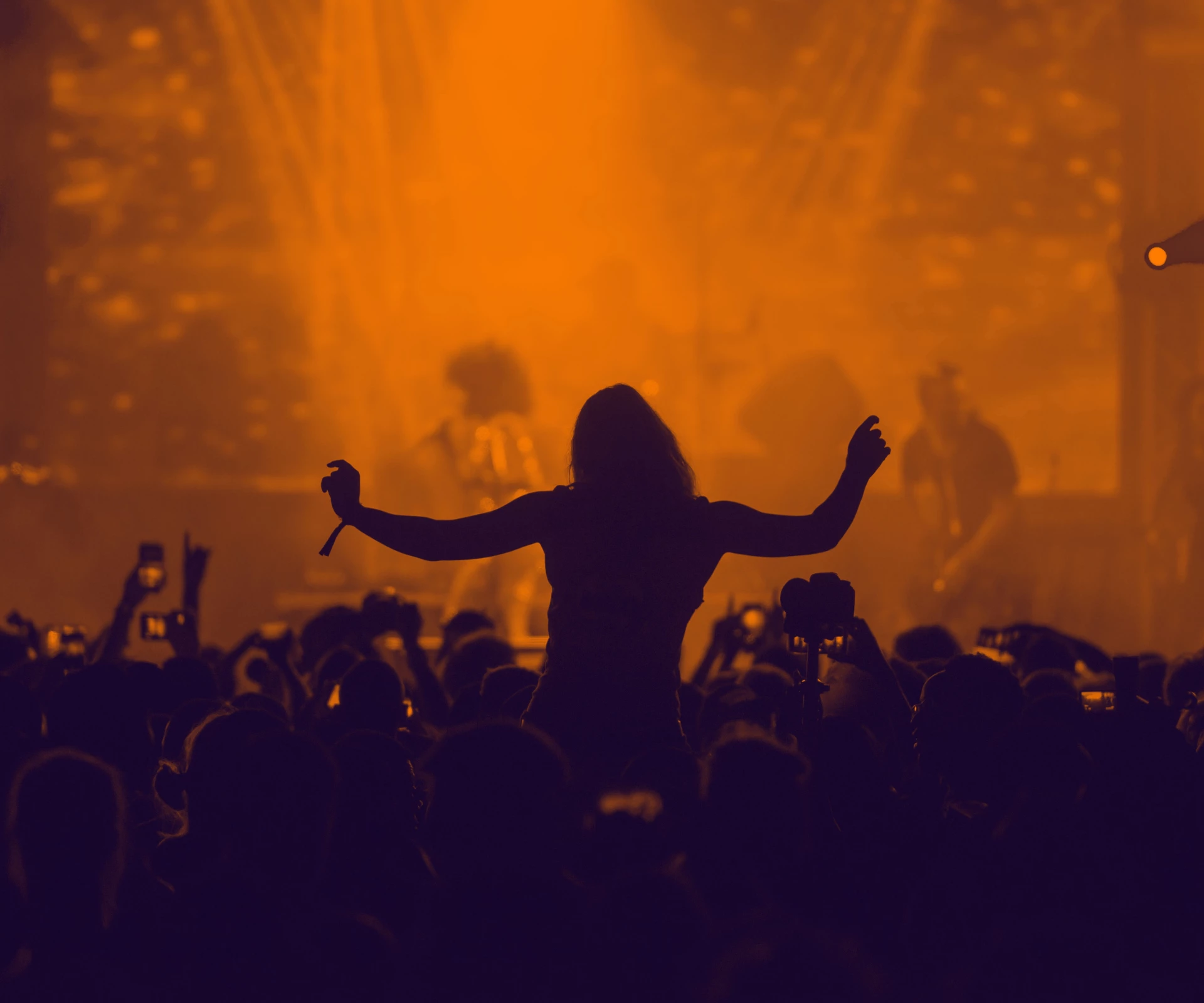 a person with their arms up in front of a crowd of people