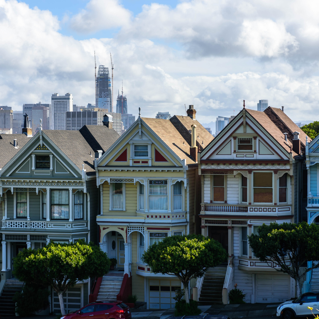 a row of houses with trees and a city in the background