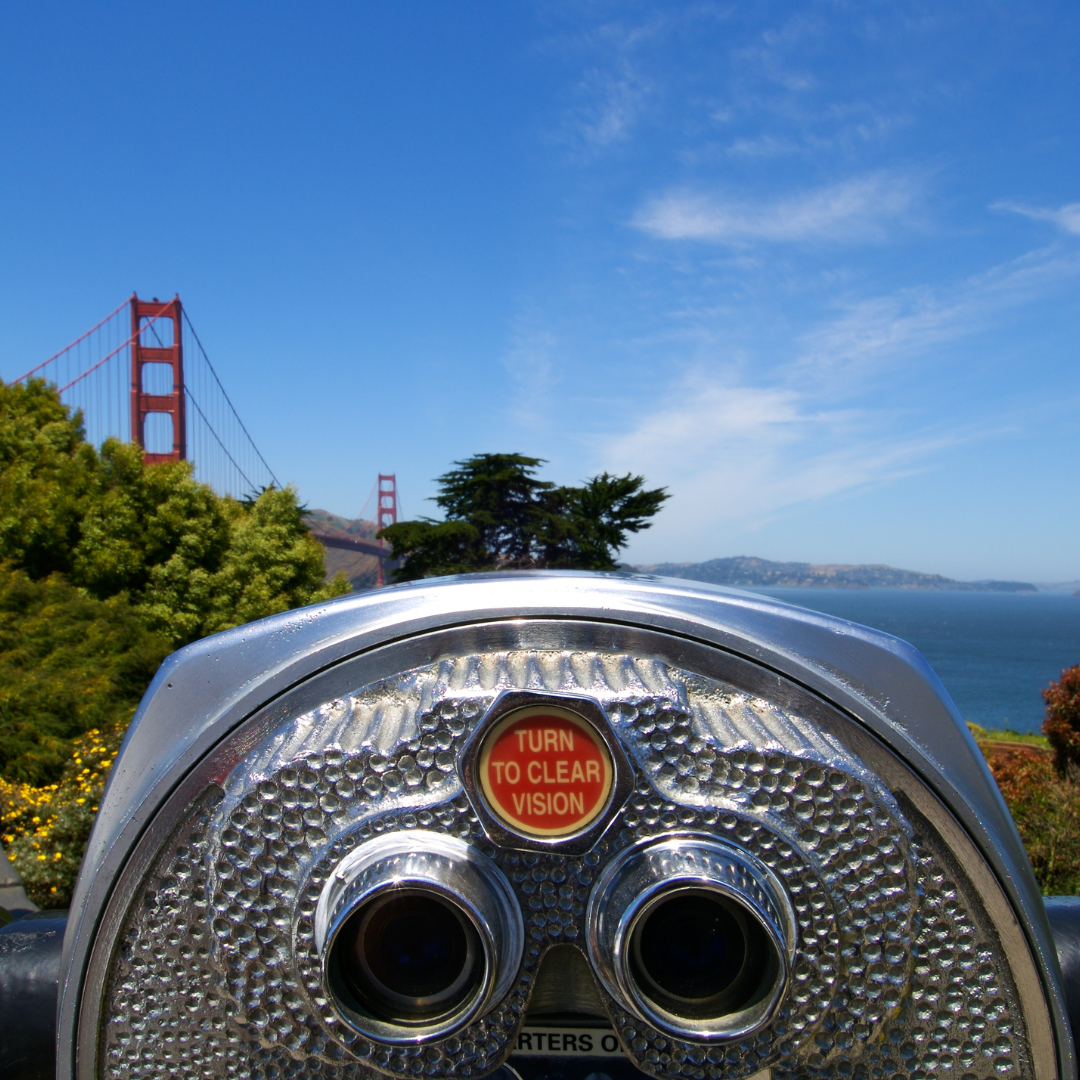 a binoculars on a hill overlooking a bridge