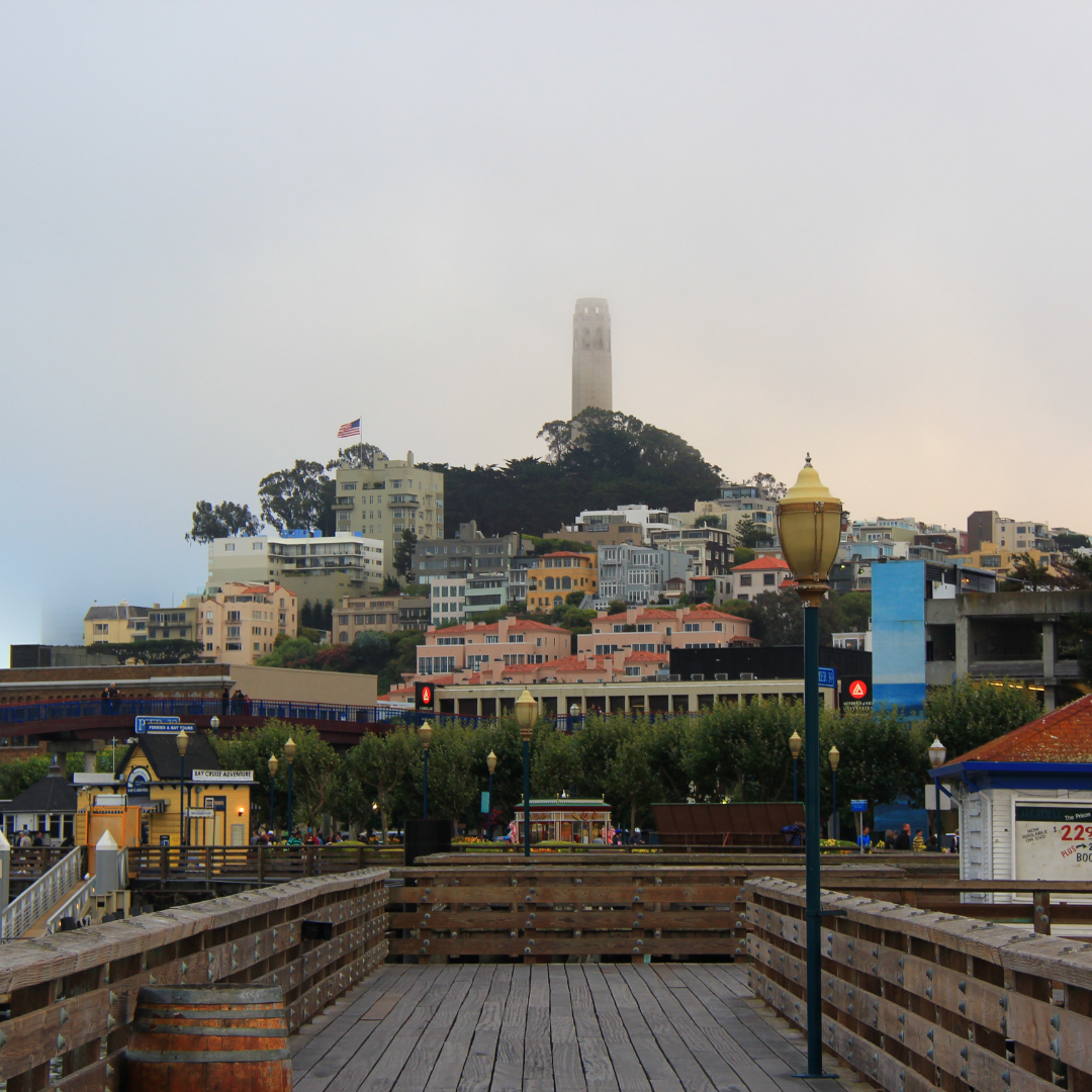 a wooden walkway with a tall tower in the background