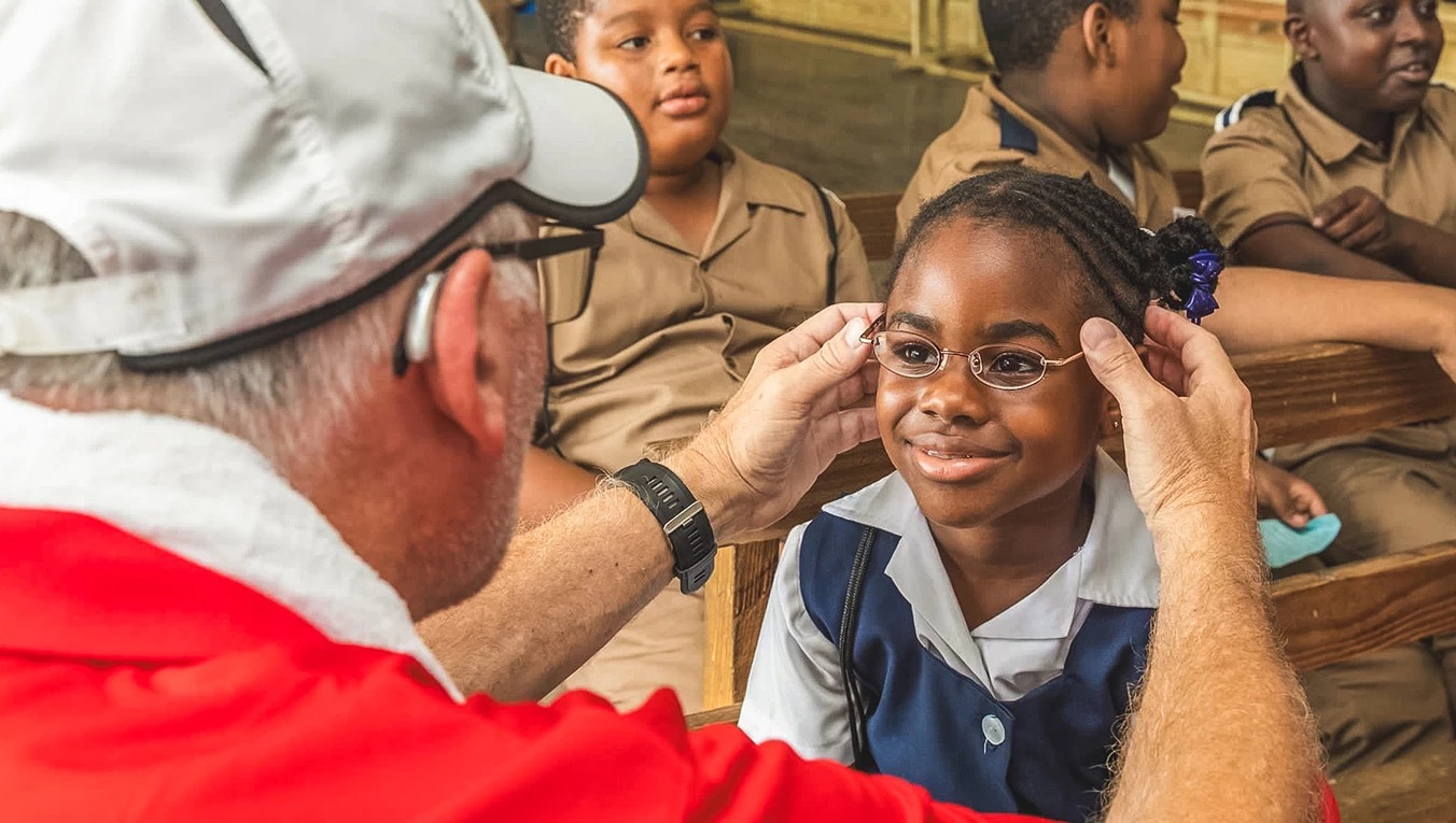 a man putting on glasses to a girl's face