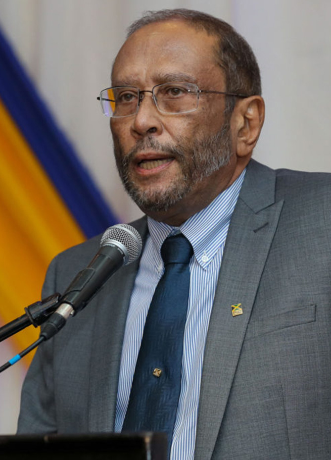 a man in a suit and tie speaking into a microphone