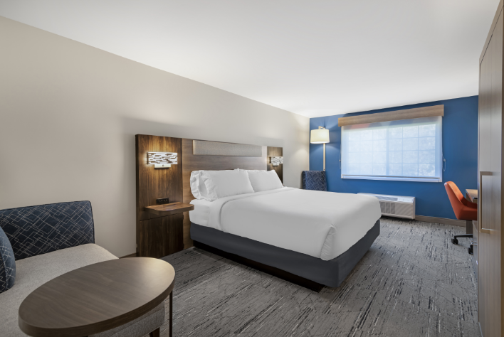 a hotel room with a bed and chairs