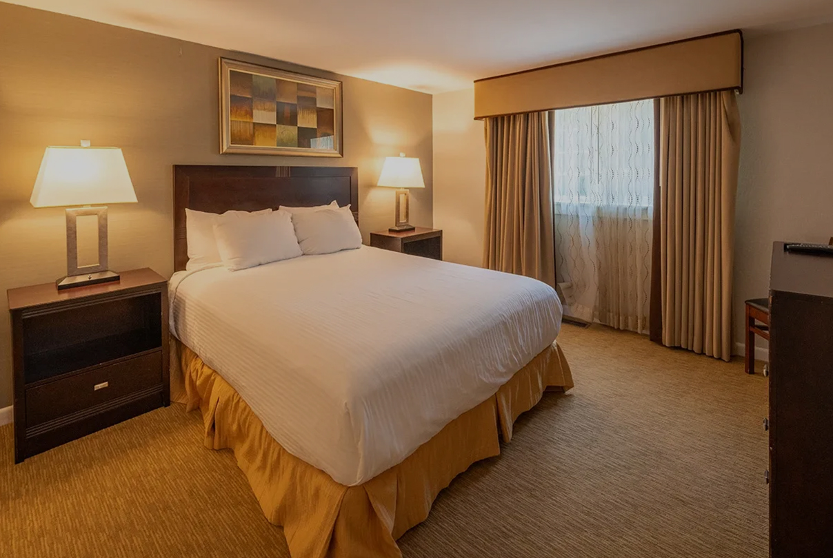 a bed with a lamp and a picture on the wall