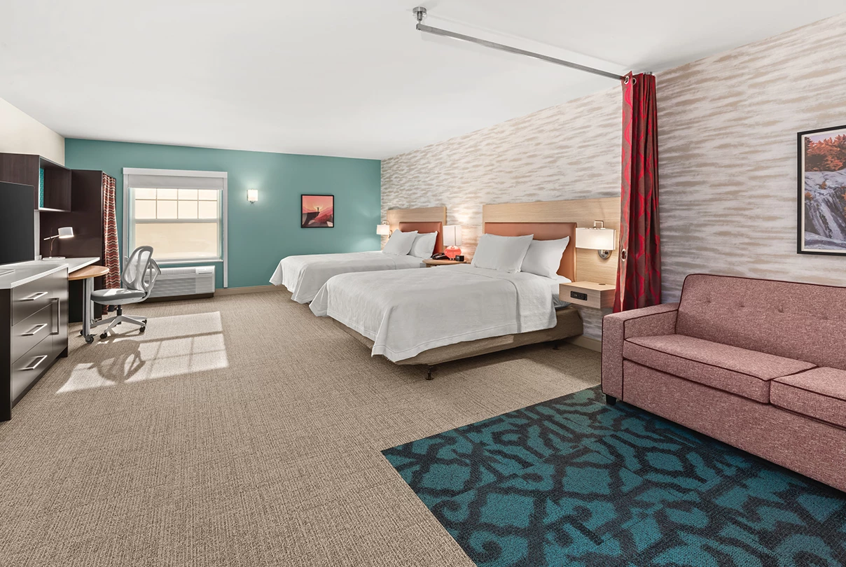 a hotel room with two beds and a chair