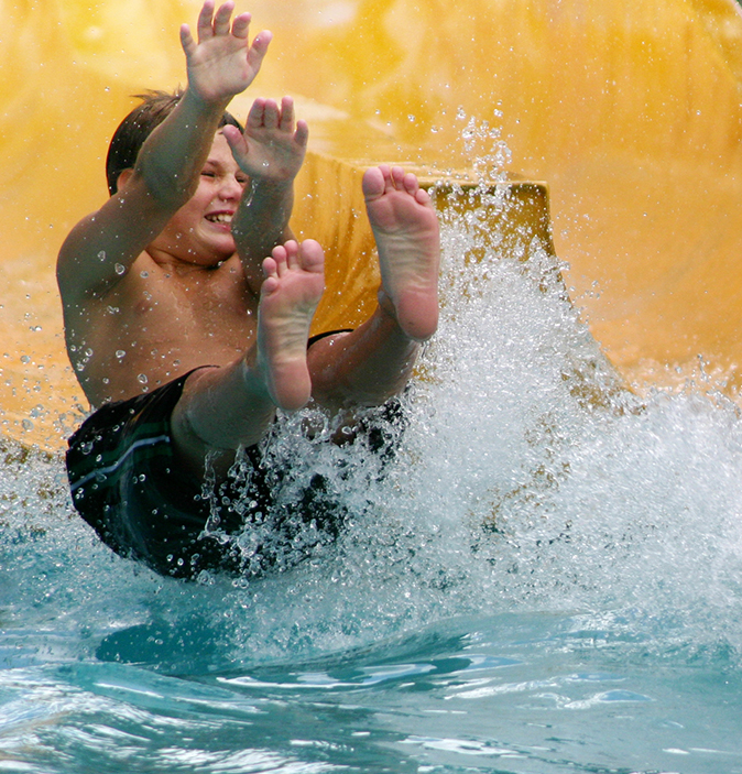 a boy sliding down a water slide