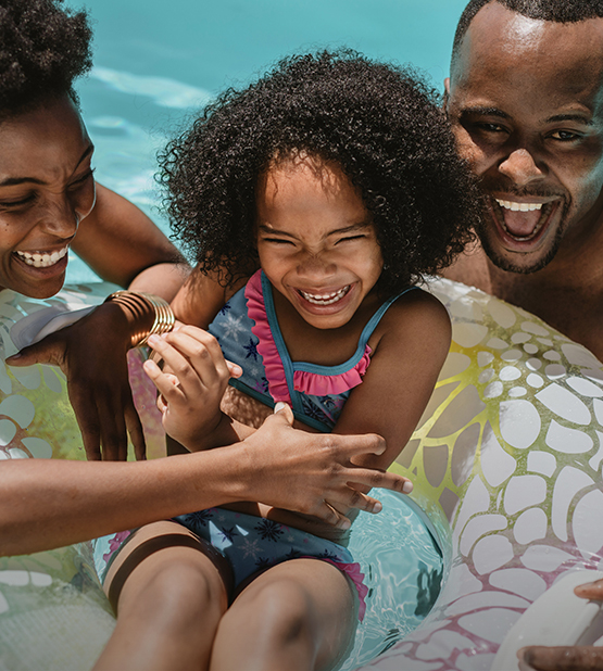 a man and woman with a child in a pool