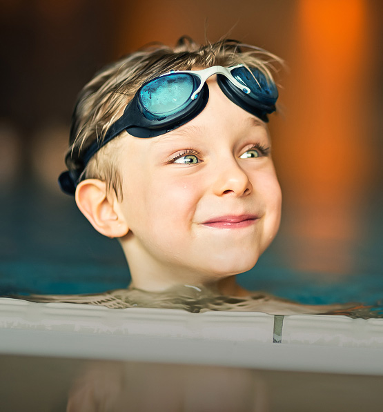 a boy wearing goggles in a pool