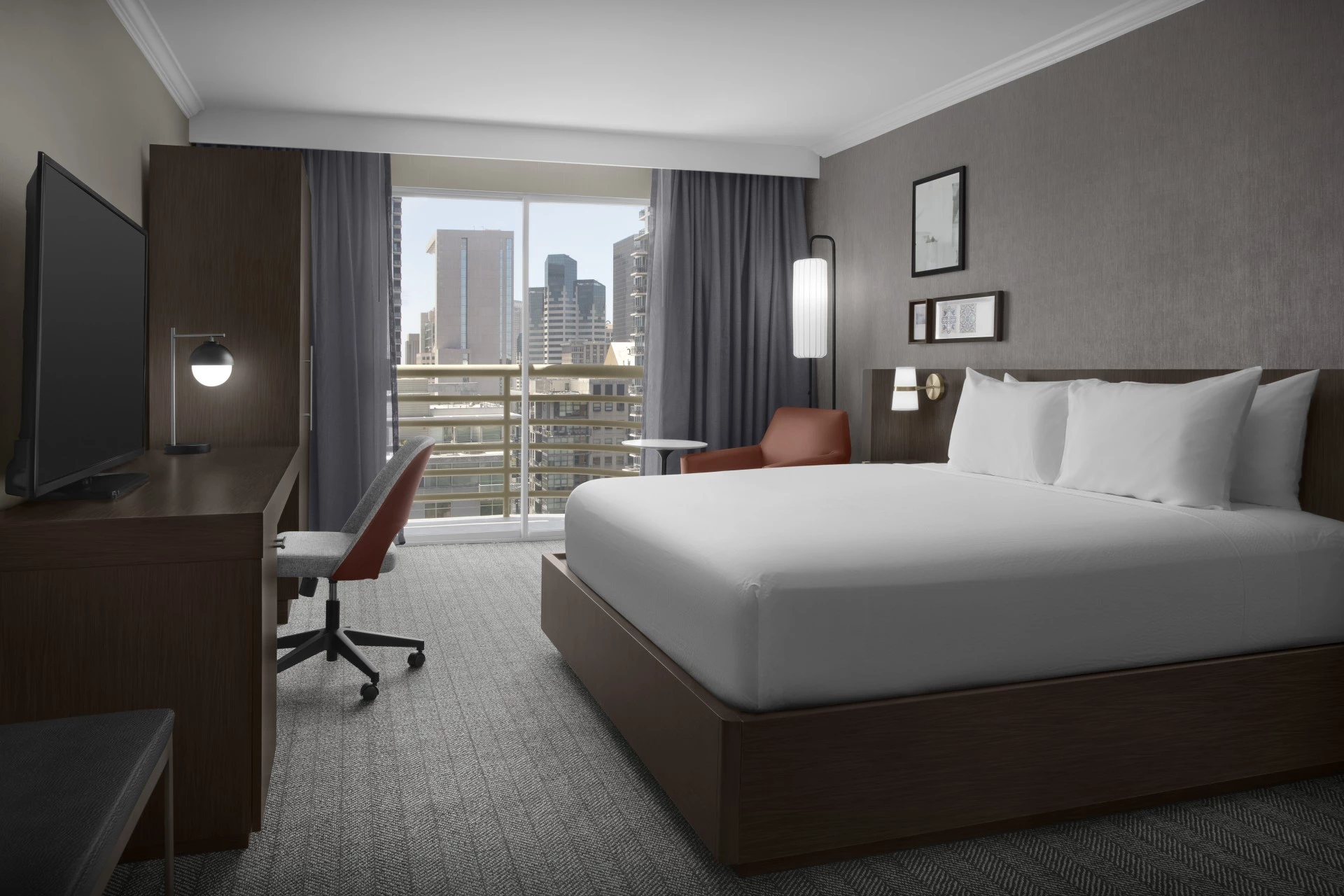 a hotel room with a bed and a desk and chair