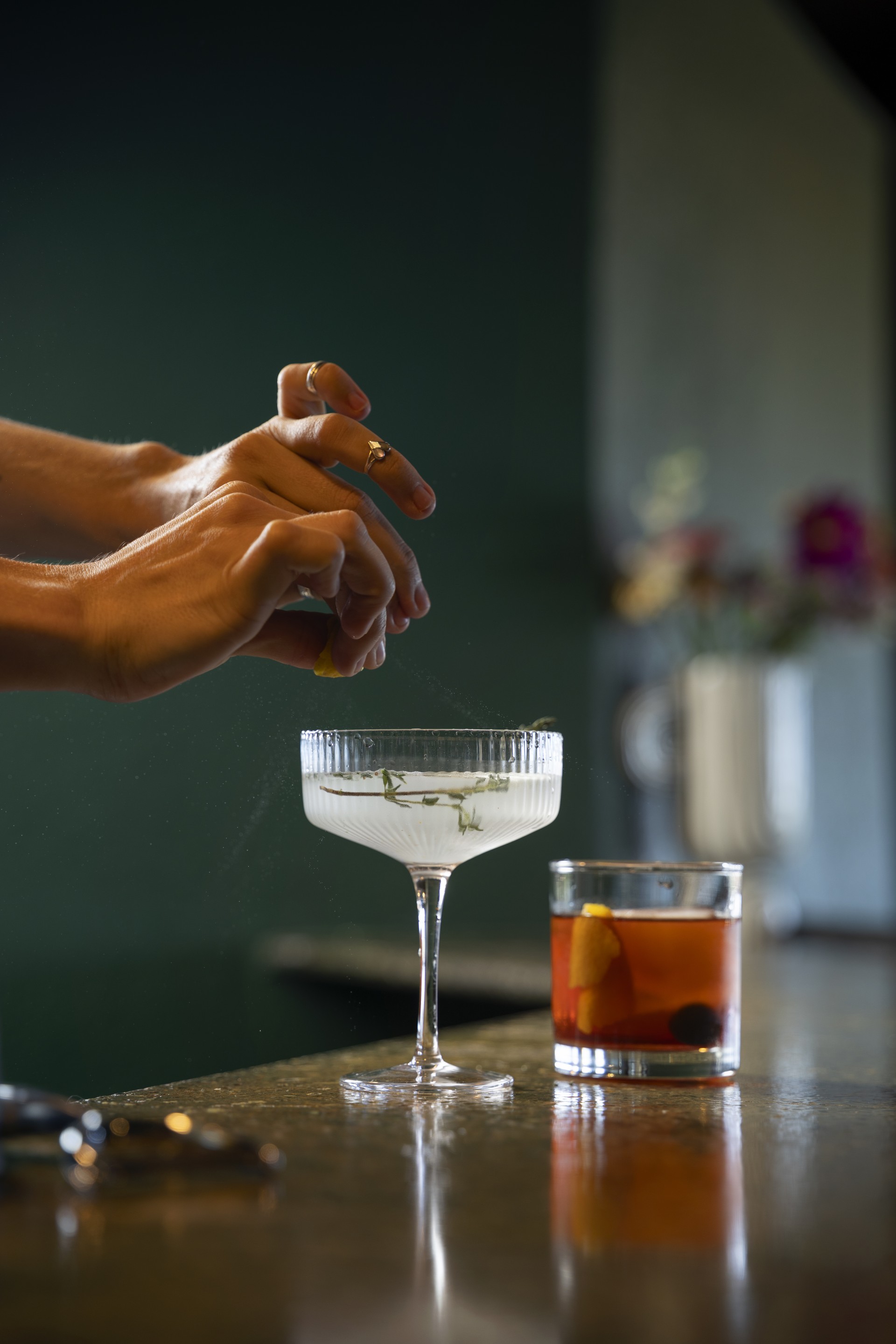 a person's hands adding a leaf to a drink