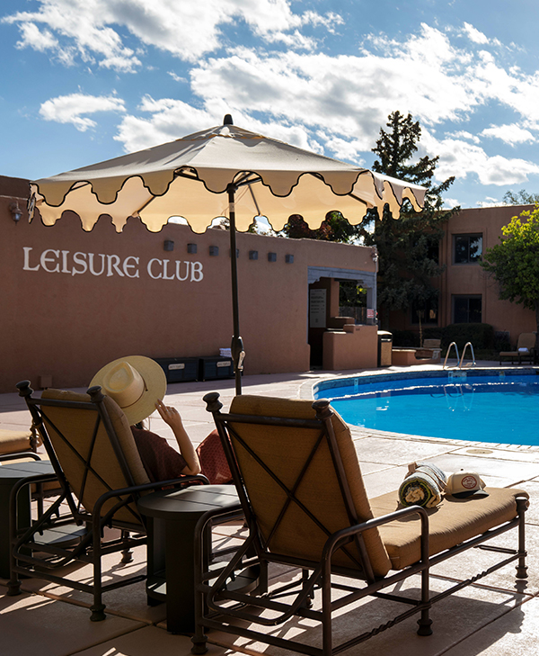 a person sitting in a chair by a pool