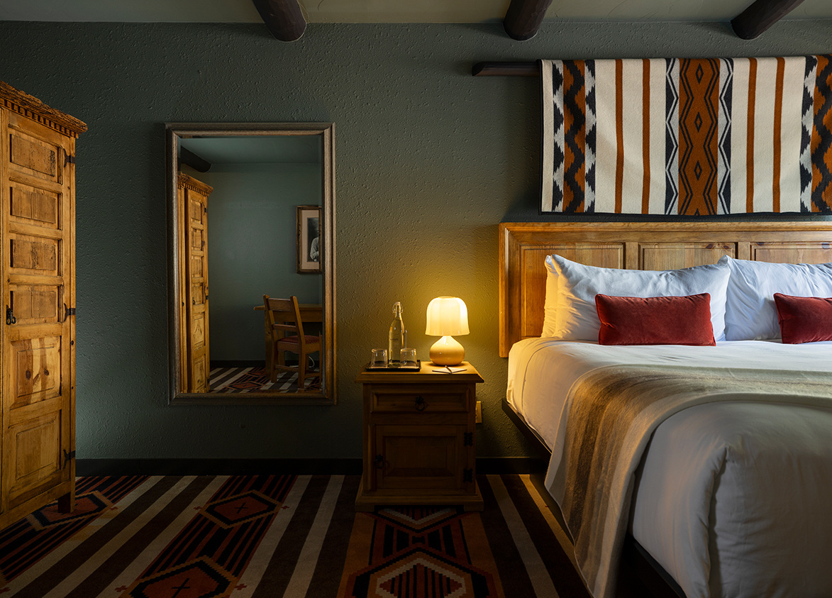 a bed with a lamp and a mirror