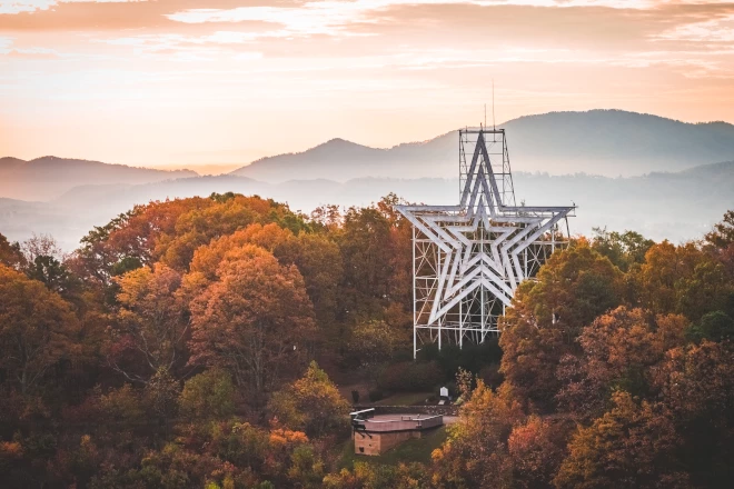 a metal structure with a star in the middle of trees