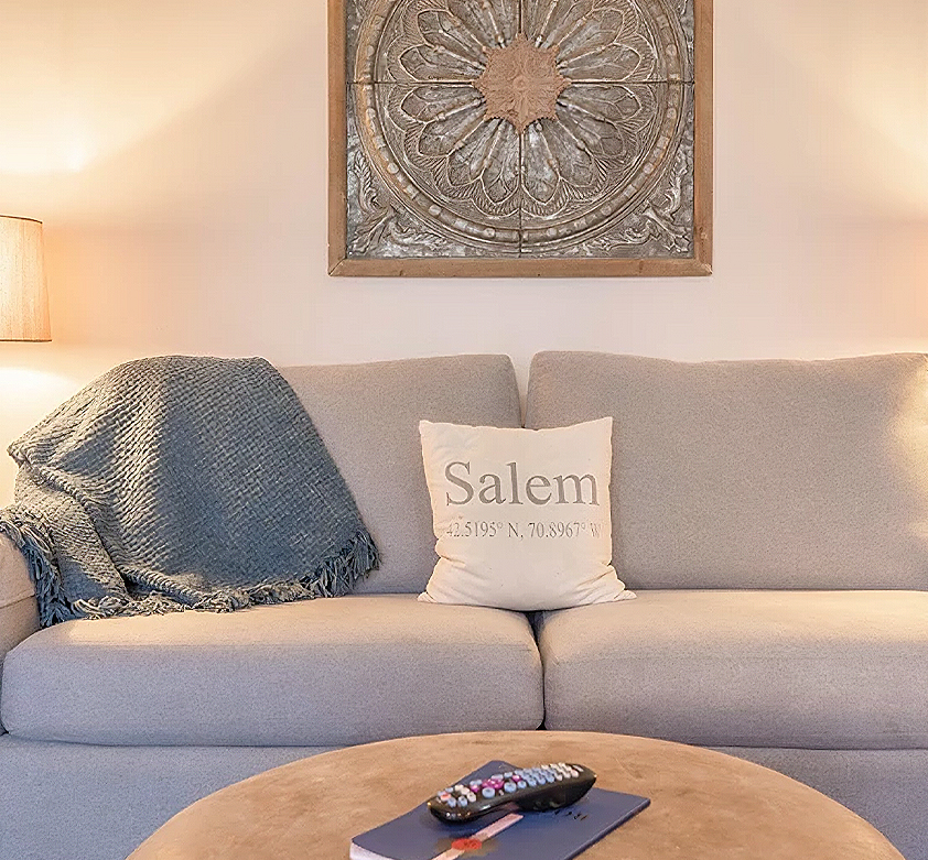 a couch with a blanket and a remote on a coffee table
