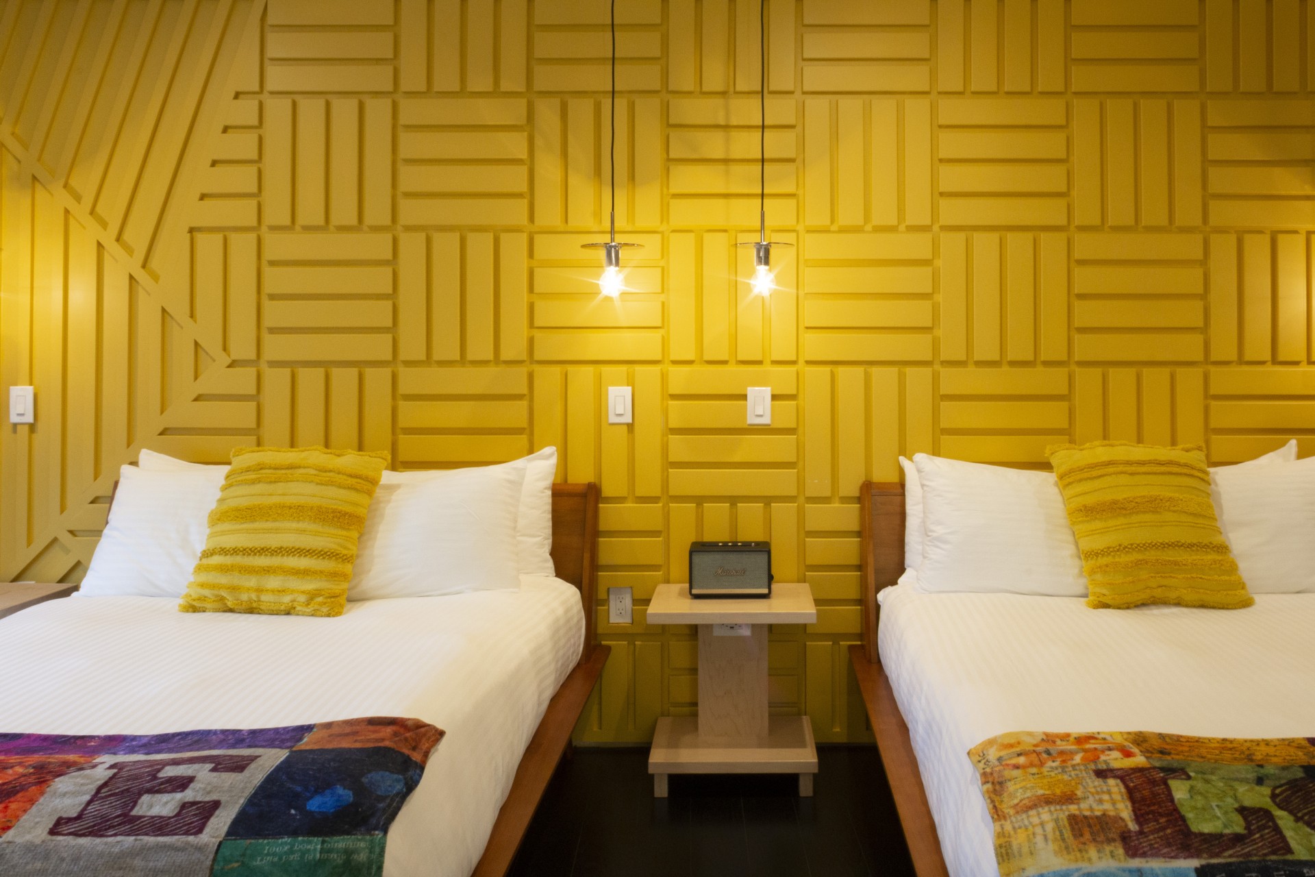 two beds in a room with yellow walls