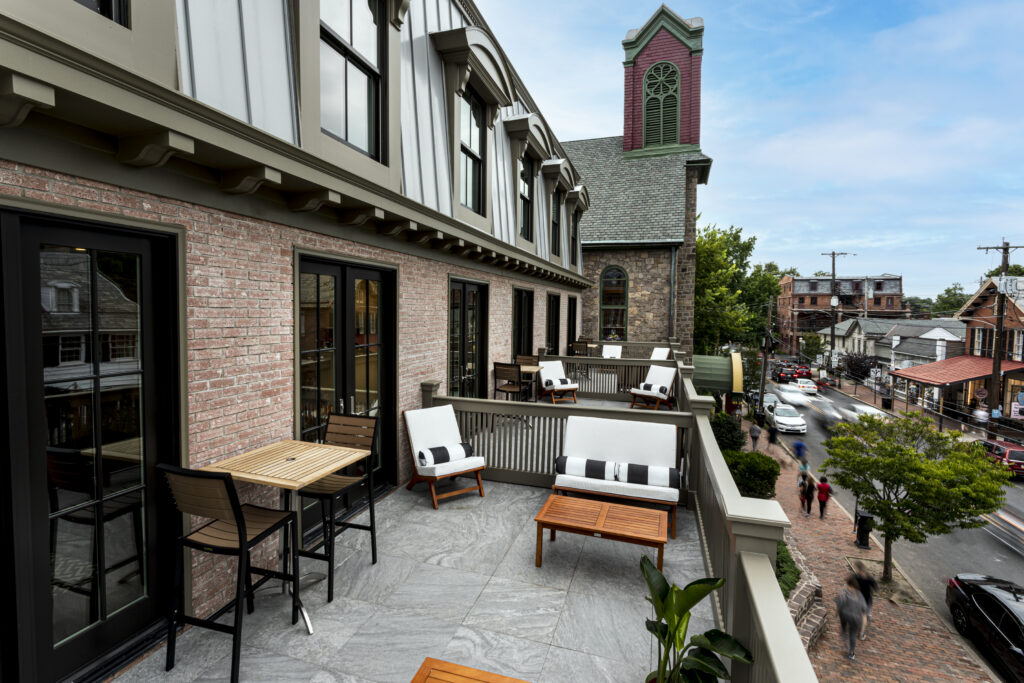 a patio with chairs and tables on a brick building